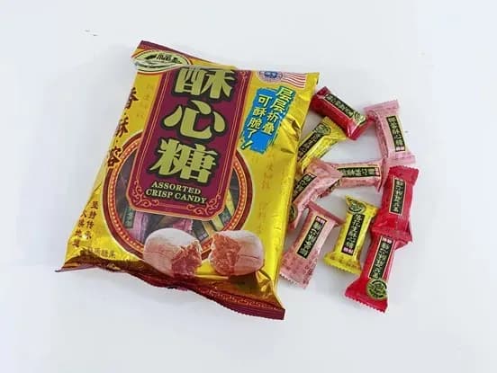 A gold bag of "Assorted Crisp Candy" with Chinese text, next to several individually wrapped candies in red, pink, and yellow wrappers.