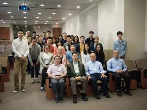 约30名以东亚裔为主的人在教室合影,前排五位男士坐着,后排站立。