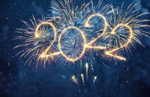 Fireworks spell out "2022" against a dark blue night sky, with other bright golden and white fireworks exploding around the numbers.