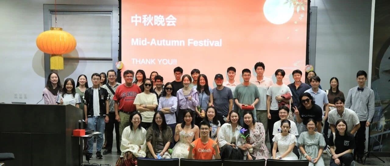 中秋晚会全体合影,背景屏幕上写着“中秋晚会 Mid-Autumn Festival”
